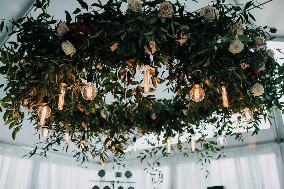 Hanging greenery and white rose installation with Edison bulbs