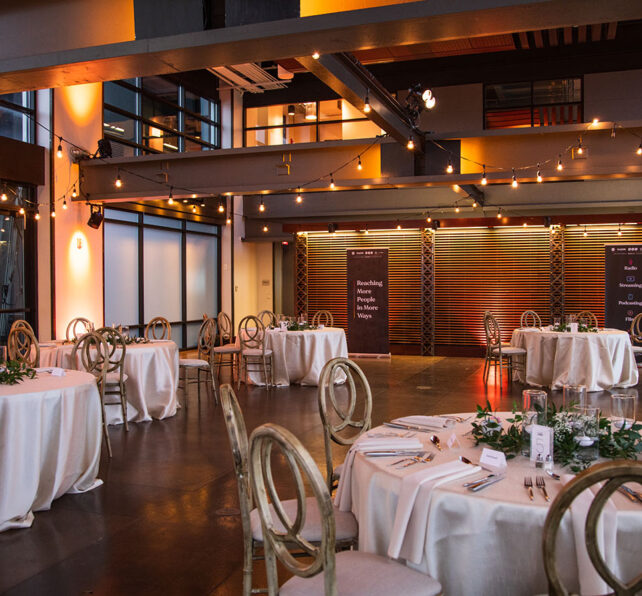 Wedding reception setup at The Bridge Building with white linens and string lights