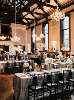 Wedding reception setup at The Bell Tower with chandelier lighting, live music stage setup, and glamorous tables