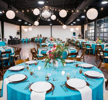 Wedding reception setup at Cherokee Dock with blue linens and white paper lanterns