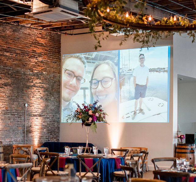 Wedding reception with projected slideshow of photos for bride and groom